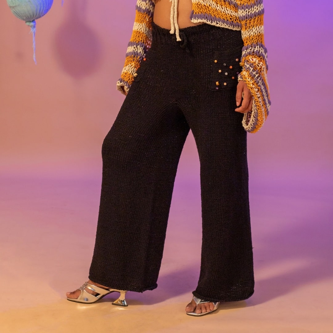 Model wearing relaxed-fit Midnight hand-knitted pants in deep black.