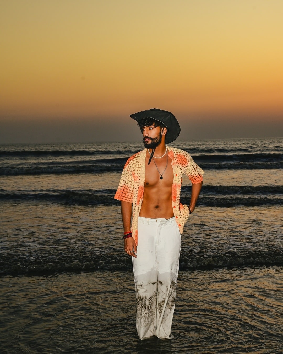 Model wearing the Sundaze Crochet Shirt on the beach, highlighting its open-stitched crochet design.