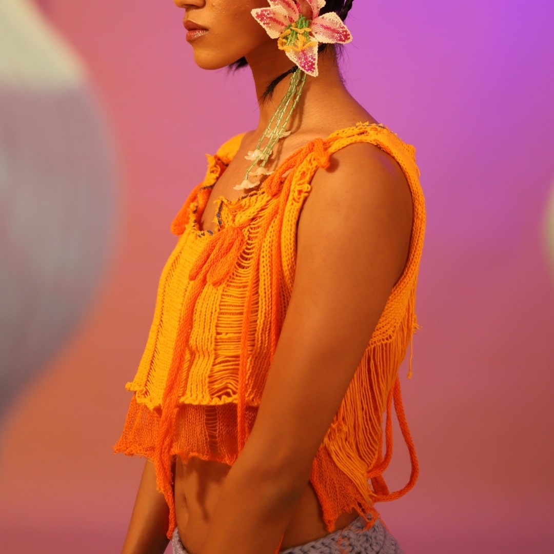Side profile of the Tangerine knitted top, featuring textured knit details.